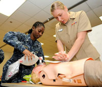  U.S. Navy Lt. j.g. Shantel Morris, left, and Ensign Kirsten Lepp, assigned to the Naval Medical Center in San Diego, practice CPR on a mannequin during a cardiac life support course. VA researchers have reported new findings on the link between mental and physical health problems in women Veterans