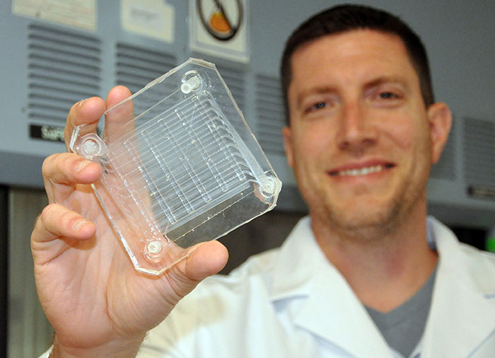 Biomedical engineer Dr. Joseph Potkay, with the VA Ann Arbor Health Care System, displays a 2D prototype of an artificial lung. A 3D version is in production. (Photo by Brian Hayes)  