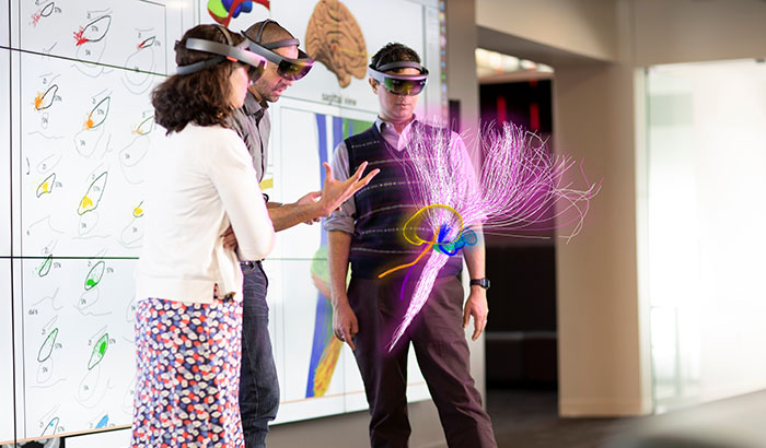 Drs. Cameron McIntyre (center) and Aasef Shaikh (right) study brain pathways through the HoloLens with neurology colleague Dr. Camilla Kilbane. The photo shows what is seen through the HoloLens glasses. (Photo provided by Cleveland FES Center) 