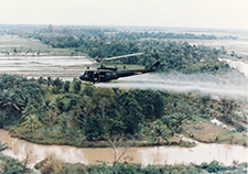 A Huey helicopter sprays Agent Orange in Vietnam. <em>(Photo: U.S. Army, via Wikimedia Commons)</em>. 