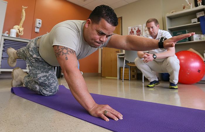 Capt. Israel Orengo is evaluated by physical therapist Tyler Snow at Madigan Army Medical Center in 2015. Snow was one of the researchers on an Army study that looked at incorporating alternative methods such as acupuncture and biofeedback into pain management.   A new study based on VA records suggests long-term benefits from service members' non-drug pain treatment.  (Photo by John Liston) 