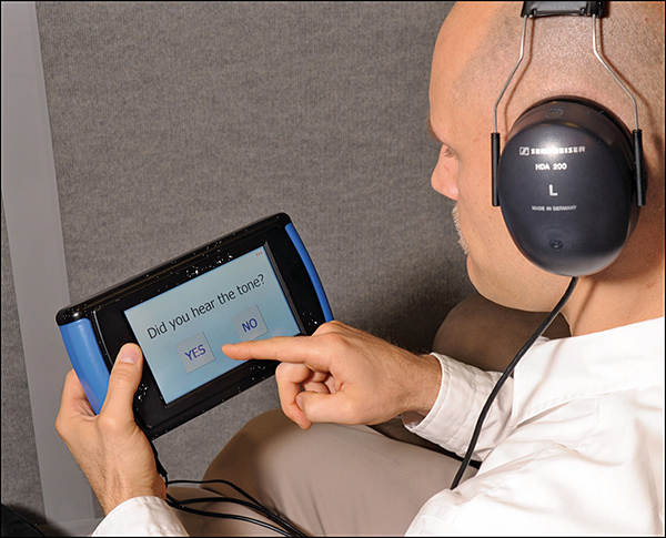 A study participant uses the OtoID system to test his hearing