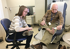 Health science specialist Tova Bergsten watches as Army Reserve Vietnam-Era Veteran Stephen Fisher uses a special thermometer to help detect early-stage ulcers in his feet. (Photo by Claudie Benjamin) 