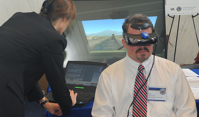 One brain-stimulation study at the Providence VA is testing the effectiveness of combining transcranial direct current stimulation with virtual reality, a form of prolonged exposure therapy, as a treatment for Veterans with chronic PTSD. In the photo, taken at a VA research exhibit on Capitol Hill in June 2019, a VA staffer tries on a virtual reality headset.  (Photo by Robert Williams)   
