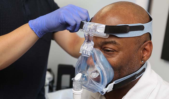 Ralph Liggins tries on a CPAP mask at the Jesse Brown VA Medical Center in Chicago. <em>(Photo by Jerry Daliege) </em> 