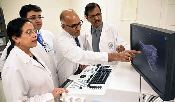 Examining a pancreatic cancer image are (from left) Drs. Snigdha Banerjee, Arnab Ghosh, Suman Kambhampati, and Sushanta Banerjee. (Photo by Jeff Gates) 

  