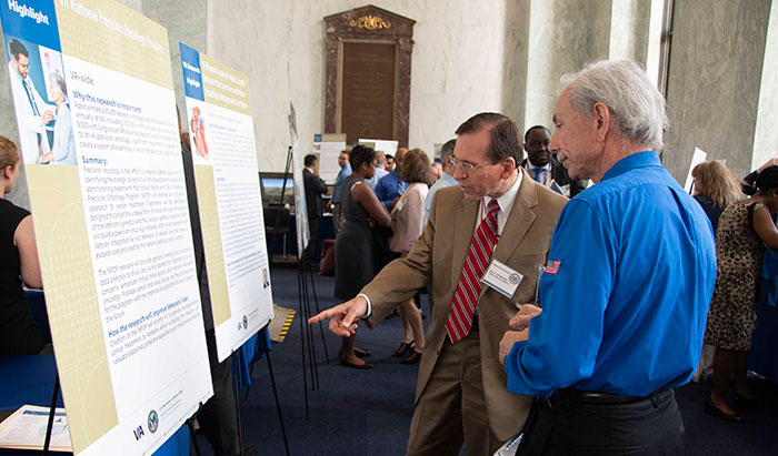 Drs. Christopher Bever (left) and Mario Rinaudo of VA’s Office of Research and Development view a poster during VA Research Day on the Hill. (Photo by Alvin Williams) 