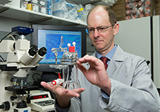 Dr. Jason Wertheim, a surgeon and biomedical engineer at the Jesse Brown VA Medical Center in Chicago, is working on developing an artificial kidney. Here he holds a bioreactor that cultures cells that play a role in creating the artificial organ.  