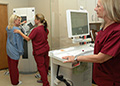 Screen team-Mammography technicians (from left) Michelle Eason, Christy Bullington and Michele Rosenberry demonstrate how a patient is positioned for a mammogram at the Fayetteville (N.C.) VA Medical Center Radiology Clinic. (Photo by Robin DeMark) 