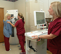 Screen team-Mammography technicians (from left) Michelle Eason, Christy Bullington and Michele Rosenberry demonstrate how a patient is positioned for a mammogram at the Fayetteville (N.C.) VA Medical Center Radiology Clinic. (Photo by Robin DeMark)