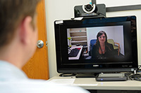 Remote healing-PTSD therapy delivered through videoconferencing proved effective in one of the largest trials yet of the approach. Seen on the screen is study coordinator Janel Fidler of the VA San Diego Health Care System. (Photo by Christopher Menzie) 