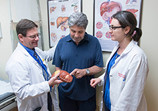 Carlos Velez, a Marine Veteran who underwent a liver transplant in 2010 at the VA Pittsburgh Healthcare System, meets with clinician-researchers Drs. David Kaplan and Marina Serper at the Corporal Michael J. Crescenz VA Medical Center in Philadelphia. <em>(Photo by Harry Maxwell)</em> 