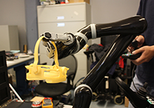 A robotic arm grasps a 3D-printed basket in HERL's robotics laboratory. 