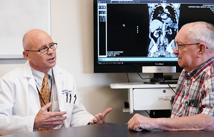 Dr. Bruce Montgomery meets with Navy Veteran Allen Petchnick, whose prostate cancer has been effectively treated to date with targeted therapy. (Photo by Christopher Pacheco) 