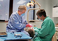     Dental assistant Freda Reutz (left) and Dr. Ronald Pleis attend to a patient at the Central Arkansas VA Healthcare System. (Photo by Jeff Bowen)