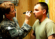   Army Lt. Col. (Dr.) Margaret Swanberg checks the pupils of Army Spc. Michael Woywood for dilation during a concussion evaluation demonstration at
        Forward Operating Base Hammer in Iraq in 2008. Research has confirmed a link between TBIs and increased dementia risk later in life. <em>(Photo by Pfc.
        Michael Schuch)</em>