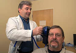   Veteran John Emmons undergoes a TMS treatment with Dr. Robert Folmer as part of a study at the Portland VA Medical Center.   