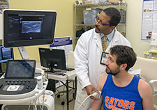 Dr. Michael Harris-Love and Mr. Brian Hoover (a member of Harris-Love's lab) demonstrate the use of ultrasound to detect sarcopenia. (Photo by Andrew White)