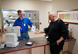 Veteran Ron Deluca receives a prescription from pharmacy technician Patrick Malloy at the VA Pittsburgh Healthcare System. A study found that VA's nationwide pharmacy system achieves huge cost-savings, relative to Medicare, by taking better advantage of generic drugs.