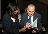 Dr. Schally gives his autograph to Marcia Lysaght, associate director for patient care services at the Miami VA Healthcare System. 