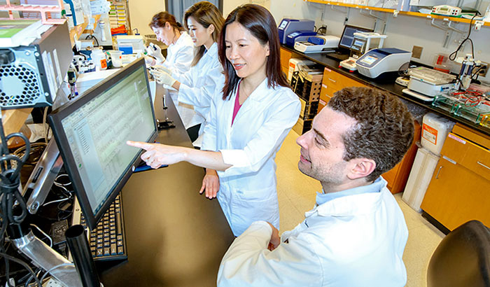 In their lab at the Atlanta VA and Emory University, Dr. Thomas Wingo and Dr. Aliza Wingo (foreground) have found genes and corresponding proteins that could open doors for new depression treatments. <em>(This photo by Lisa Pessin was taken before the current pandemic.