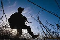 An Army soldier patrols in Afghanistan, in March 2011. Researchers are exploring how to distinguish between overlapping symptoms of PTSD and traumatic brain injury. 