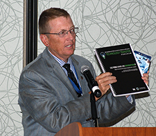 Dr. John Kaplan, an Air Force Veteran and director of VA's Technology Transfer Program, shows attendees at the CDA meeting a booklet his office has developed to guide them in disclosing inventions and intellectual property, and working with VA on patents, licensing, and commercial development. <em>(Photo by Mitch Mirkin)</em>  