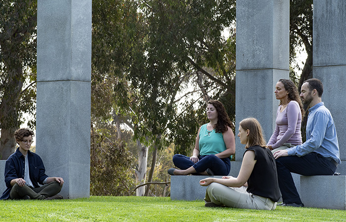Dr. Ariel Lang (second from right) practices meditation with associates from her lab. She's focusing on complementary and alternative techniques, such as yoga and meditation, as a therapy for patients with PTSD. (Photo by Christopher Menzie)