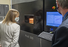 VA Acting Deputy Secretary Pamela Powers peers through the view port to watch the fabrication of COVID-19 testing swabs. HERL may ramp up its production to as many as 100,000 swabs per week. (Photo by Bill George)