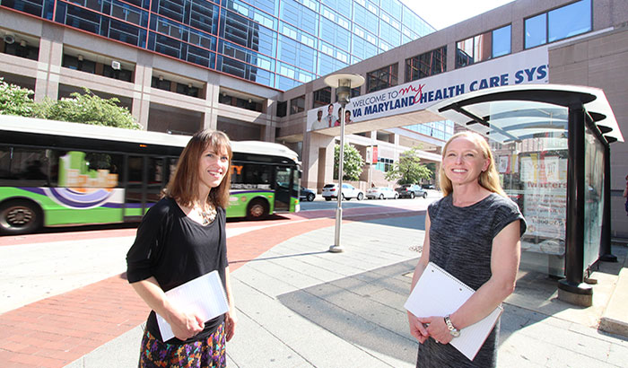 Drs. Erin Romero (left) and Melissa Barone are seen near a bus stop that was one of several starting points for Veterans going on group outings, with a therapist, as part of exposure therapy for PTSD. (Photo by Mitch Mirkin)  