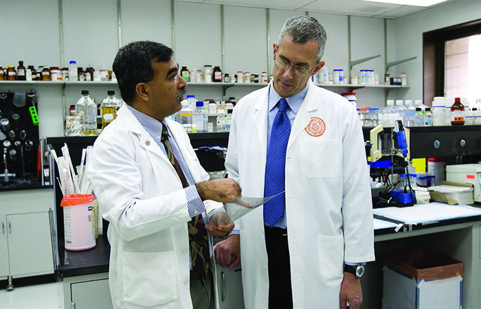   VA's Dr. Sunil Ahuja (left), seen here in a file photo with collaborator Dr. Matthew Dolan, is leading a joint project with NIAID to learn more about the factors that affect the severity of illness from COVID-19.  The study is part of an expanding partnership between the two agencies. (Photo by Lupe Hernandez) 