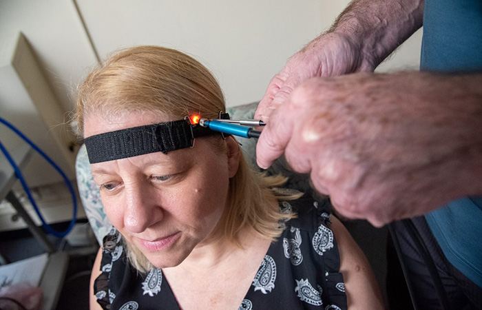 VA researchers at the VA Bedford Healthcare System demonstrate how near-infrared spectroscopy is used to detect brain changes possibly linked to Alzheimer's disease. (Photo by Frank Curran) 