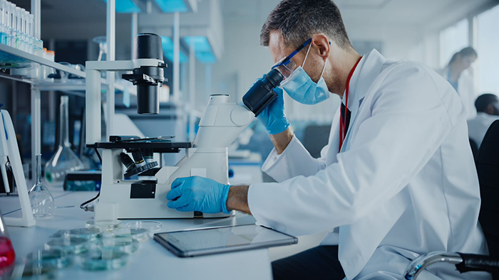 Male researcher using a microscope  © Getty Images/gorodenkoff  