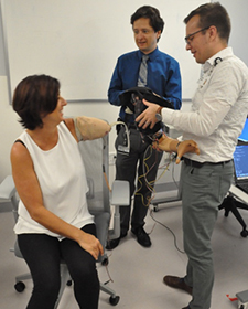 A study participant with an above-elbow amputation prepares to don her prosthetic arm. Her residual limb is covered with a smooth, pliable silicone liner to avoid irritation from the hard socket that connects the prosthetic arm to her body. (Photo by Courtney Shell/APT Center)  