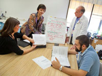 Veteran Lonny Ellison (right) works with an occupational therapy team as part of a special cognitive training program at the San Francisco VA Medical Center. VA research has determined that for many Veterans, effectively treating PTSD and depression may help greatly in restoring cognitive function following TBI.