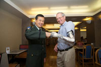 At last year's Research Week event at VA headquarters, Fred Downs Jr. (right), former chief of prosthetics and sensory aids for VA, exchanged a fist bump with Col. Geoffrey Ling of the Defense Advanced Research Projects Agency. Downs was wearing the DEKA prosthetic arm. (Photo by Emerson Sanders)   