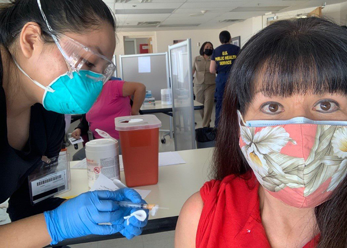 Theresa Clay (right), a member of Navajo Nation, receives her COVID-19 vaccine booster shot from a nurse with the Indian Health Service (IHS), Shayla Jim, during a recent IHS vaccination event in Albuquerque. (Photo courtesy of Indian Health Service) 