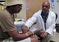 Patient-focused care-Kevin Barrett, a nurse practitioner at the Jesse Brown VA Medical Center in Chicago, sees  Veteran Alphonso Cox-Bey during a visit to the VAMC's newly opened Homeless Patient-Aligned Care Team clinic last summer. (Photo by Mike Molina) 