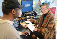 Study coordinator Elaine Nevins explains a colorectal cancer screening procedure to Navy Veteran Alex Pryor at the Seattle VA Medical Center.