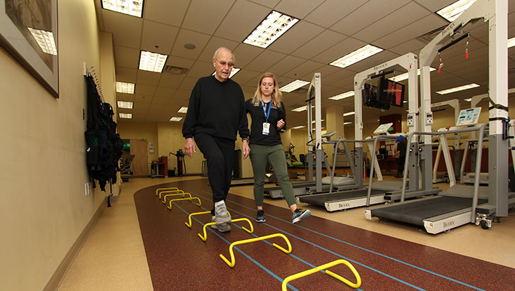 Donald Salganik, who served in the Air Force during the Korean War, proceeds through an obstacle course that is part of the “multimodal balance intervention” being studied by Baltimore VA researchers. With him is study coordinator Lydia Paden. (Photo by Mitch Mirkin)