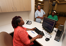 Lenarda Barksdale, a PACT clerk at the Baltimore VA Medical Center, helps Vietnam Army Veteran Jadie Sinclair with an appointment. Sinclair is accompanied by his daughter, Janice Quintana.