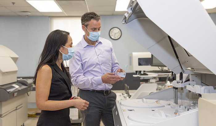 Drs. Michelle Estrella and Michael Shlipak of the San Francisco VA believe the cystatin C test is much more accurate in detecting kidney disease than the one that has long been used in standard medical practice, the creatinine test. Here, they are working with a machine that measures both tests. (Photo by Edgardo Caballero.)