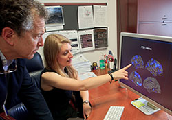   Dr. William Milberg and Emily Lindemer examine brain MRI images. The scientists are with VA's Boston-based Translational Center for TBI and Stress Disorders.
