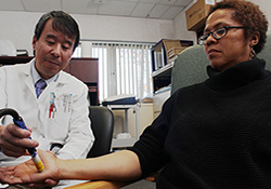   Dr. Mian Li administers a neurology test to Gulf War Veteran Melanie Yvette Jackson. 