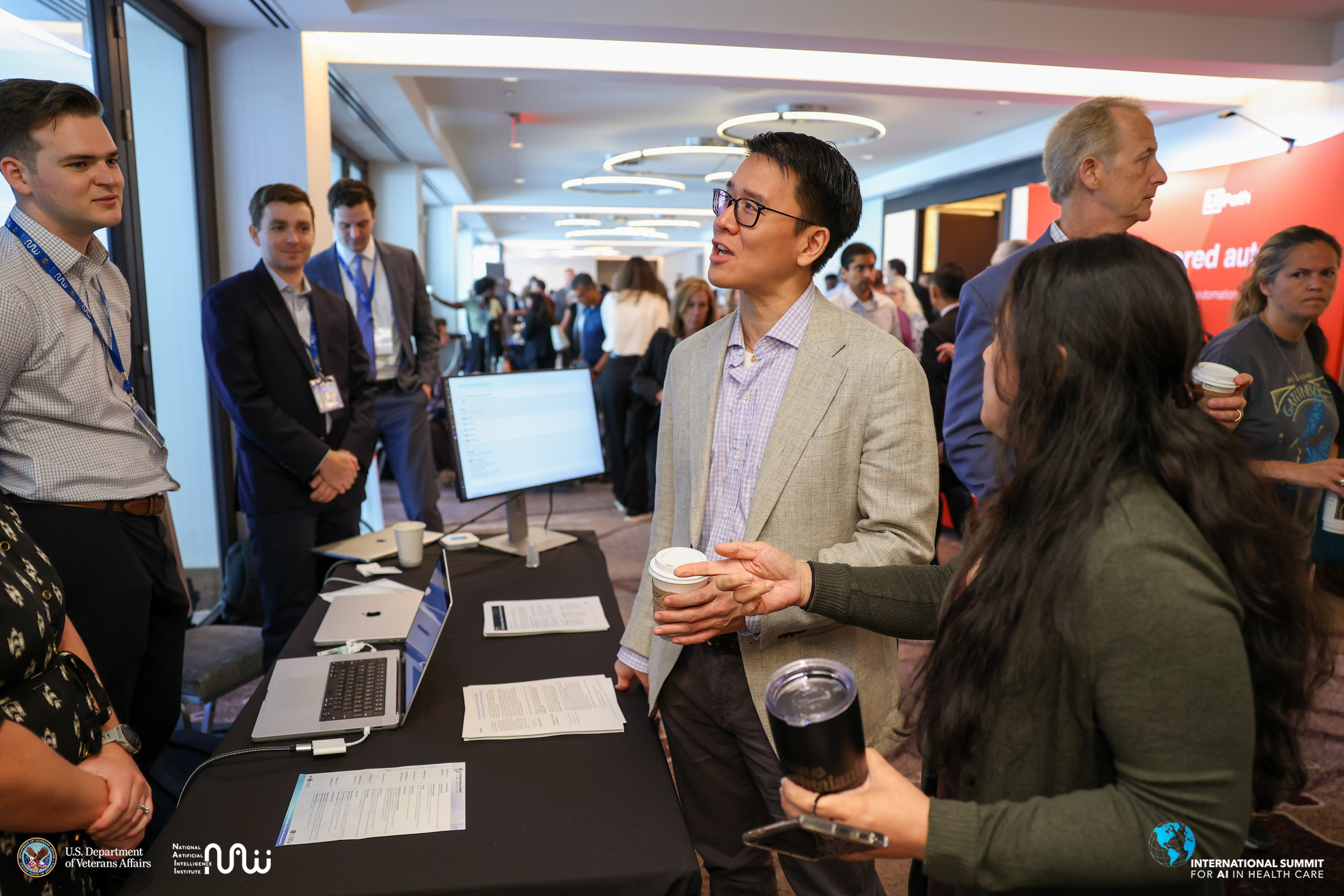 AI Summit attendees networking with exhibitors during coffee hour 