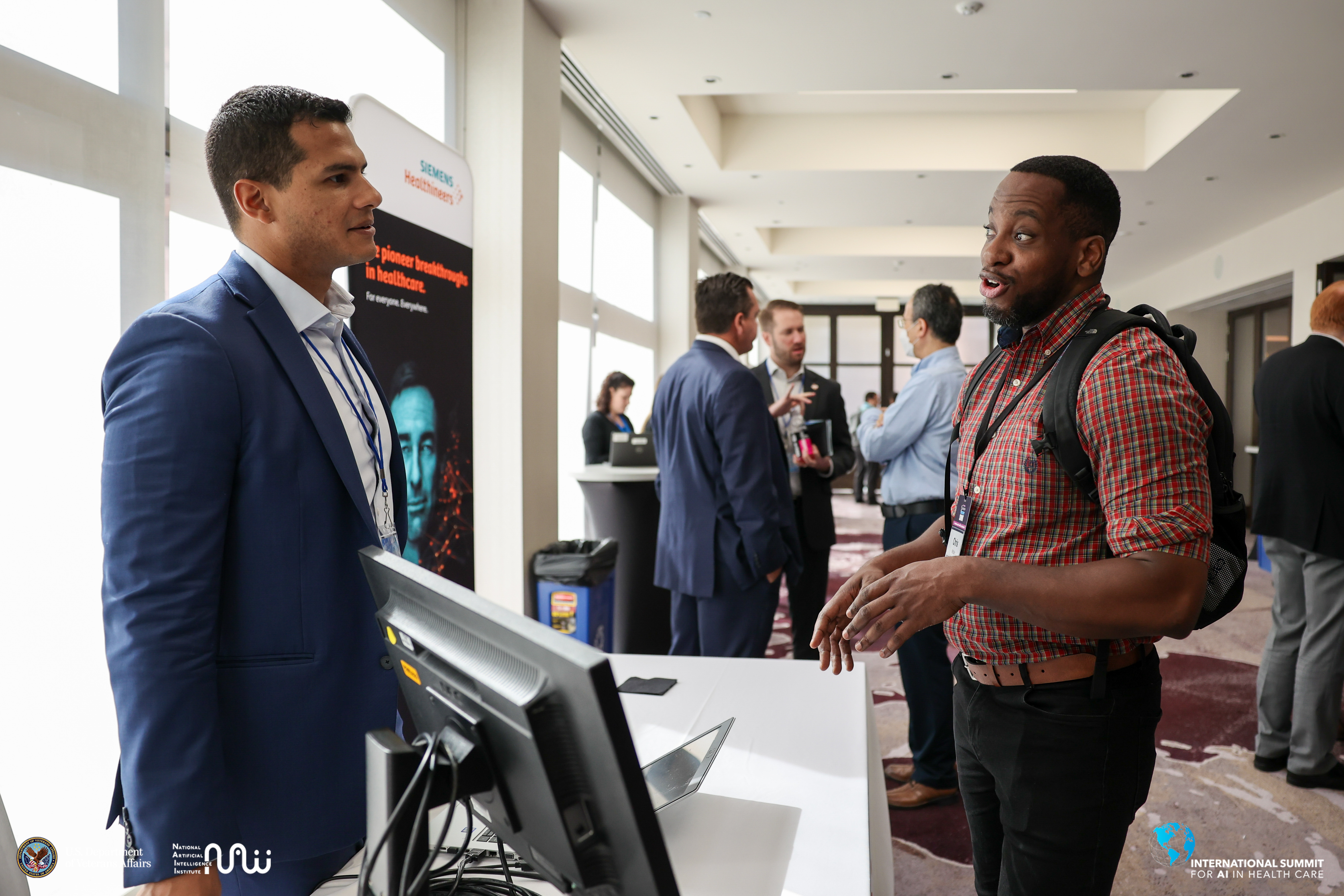AI Summit attendees networking with exhibitors during coffee hour