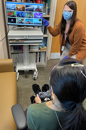 Dr. Caitlin Tyrrell and research coordinator Kim Schaper demonstrate various neurofeedback computer displays. Patients receive neurofeedback displayed as a video or a video game. As the brain receives feedback via the computer display, it slowly begins to self-correct.